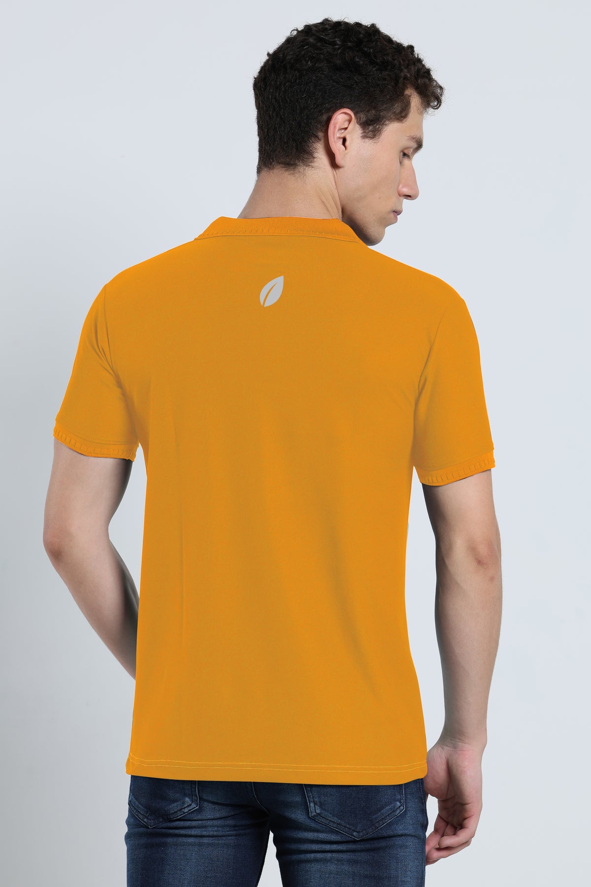 Back view of men's mustard yellow activewear polo t-shirt with subtle branding